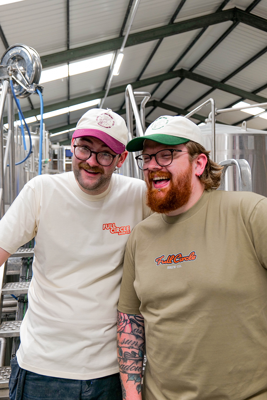 Two members of the team at Full Circle in the brewery wearing our new merch