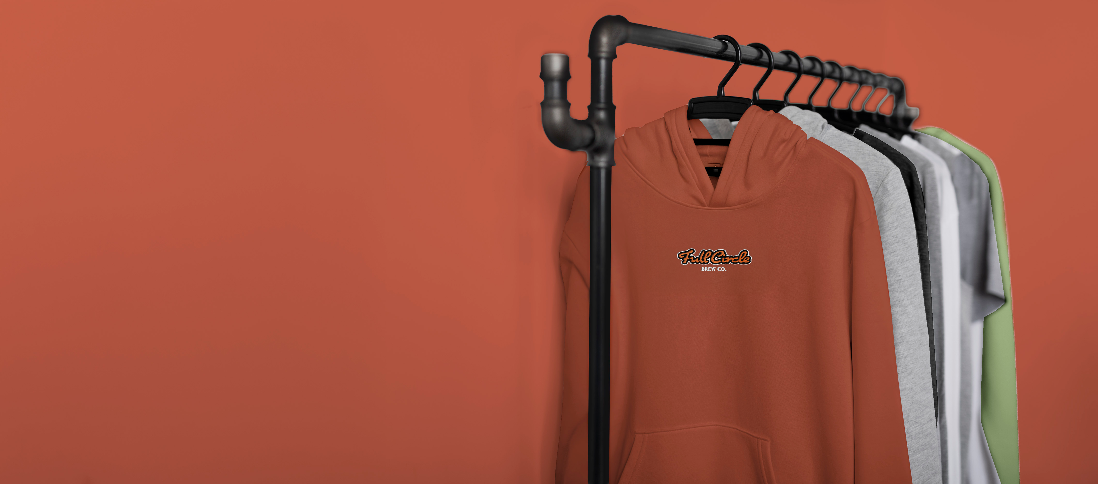 A clothing rail with a selection of Full Circle branded merch items on it